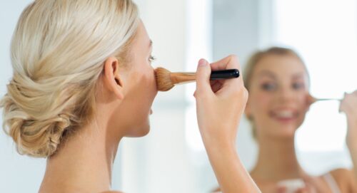 Kvinde der bruger foundation foran spejl